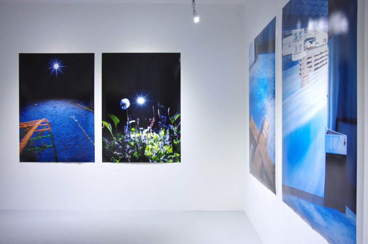 Un muro con obras de una pasarela de madera y luz azul