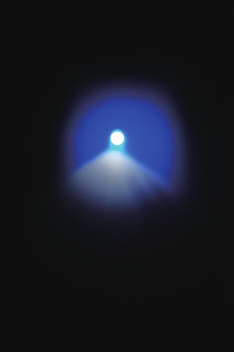 Un anillo de luz azul en la oscuridad y un cono de luz que se abre por debajo
