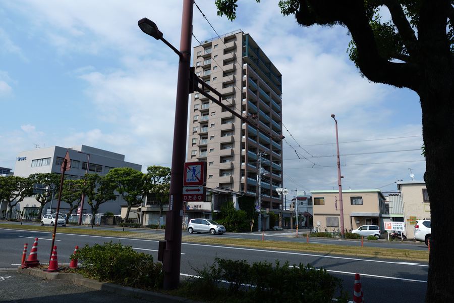 集合住宅と道路、街路樹のある屋外の風景